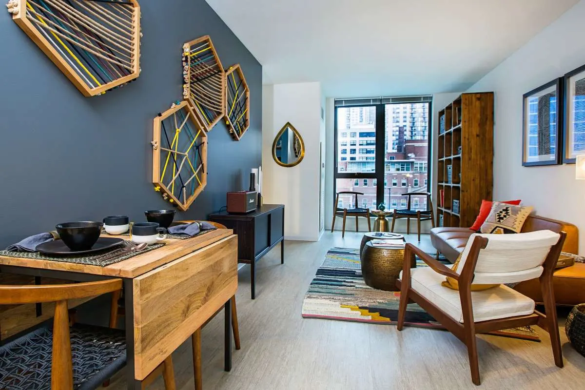 Dining table and living room with blue accent wall at Exhibit On Superior in Chicago, Illinois