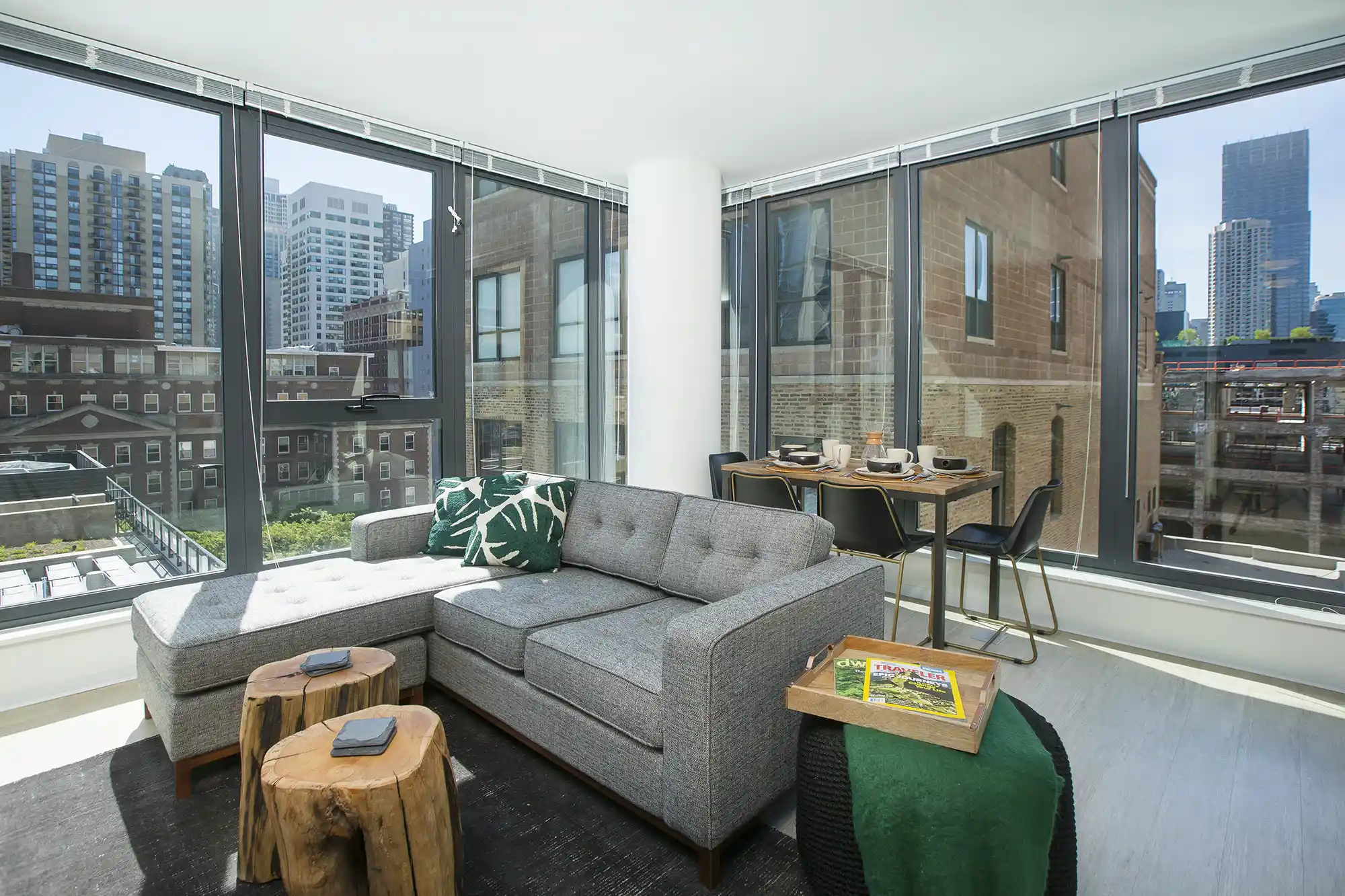 Furnished corner living room with a gray sectional and floor-to-ceiling windows at Exhibit On Superior