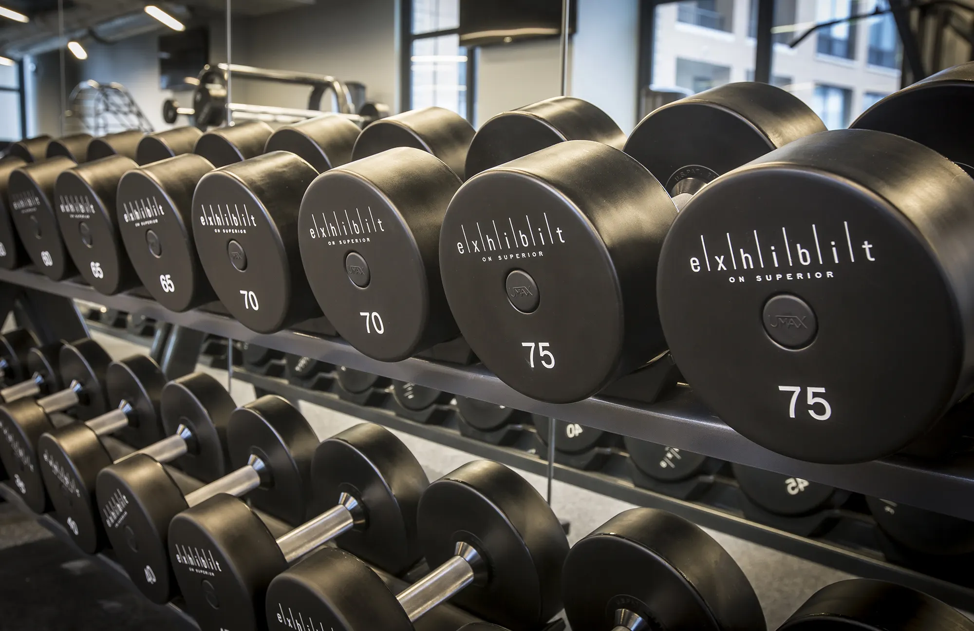 Rows of free weights in the Exhibit On Superior fitness center
